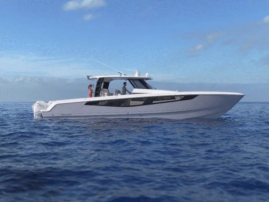A sleek white motorboat glides through calm blue waters with two people enjoying the view under a clear sky.